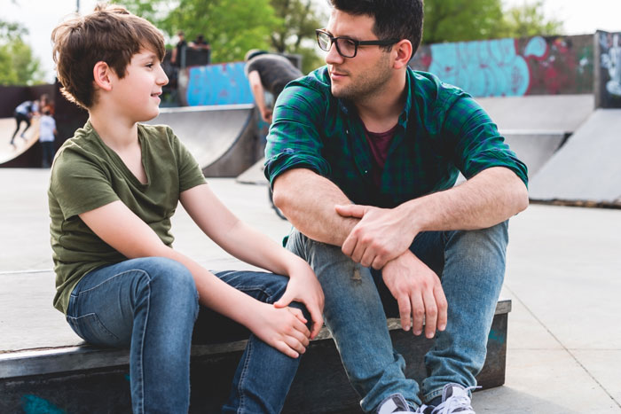 man talking to son at skate park