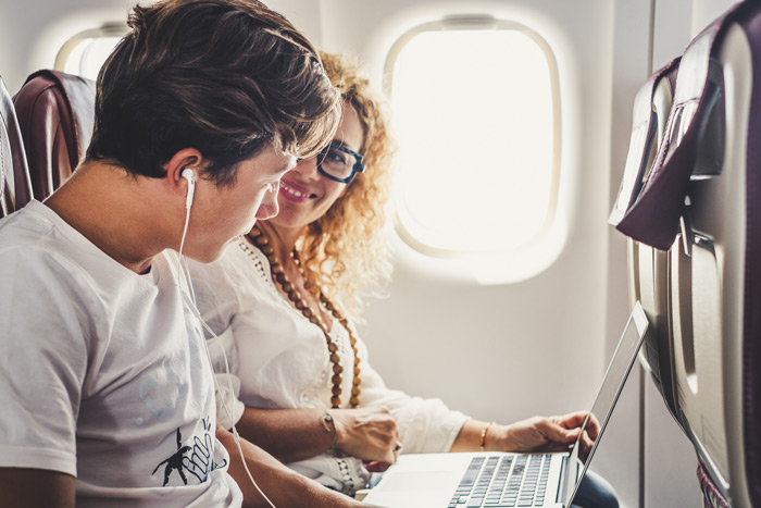 Support Your Teen in Treatment, parents support teen addiction treatment, How You Can Support Your Teen in Treatment, parents and teen addiction support, mom and son looking at a laptop on an airplane - parents