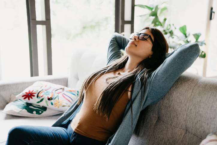 woman stretching comfortably on a couch