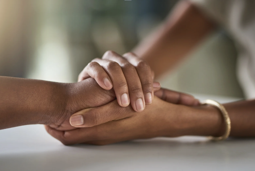 A woman's hands holding onto another's.